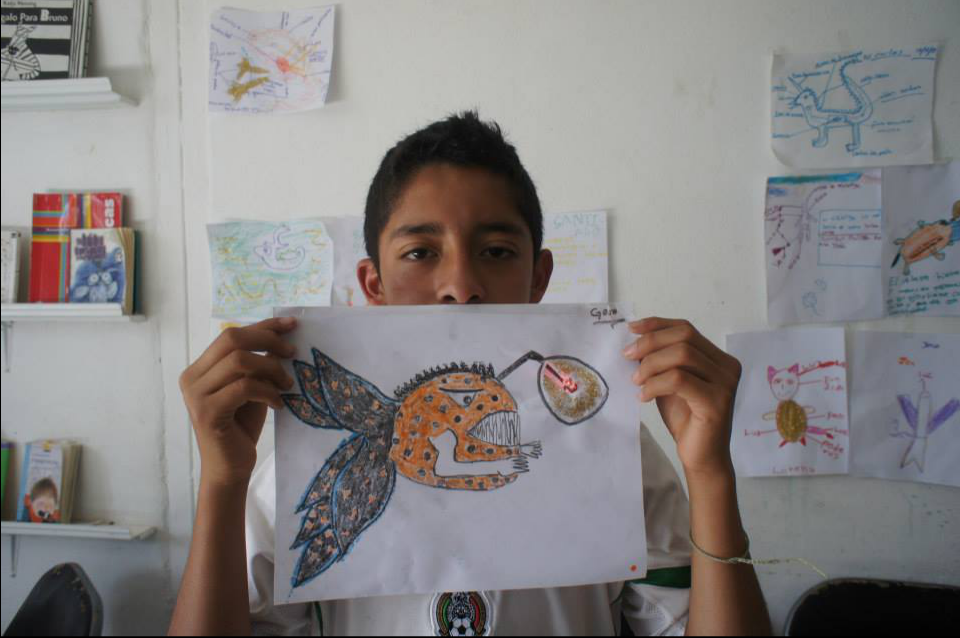 A child holding a drawing with an LED light in it. 